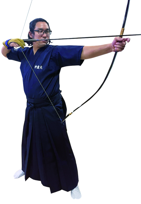 弓道部で弓を引く学生